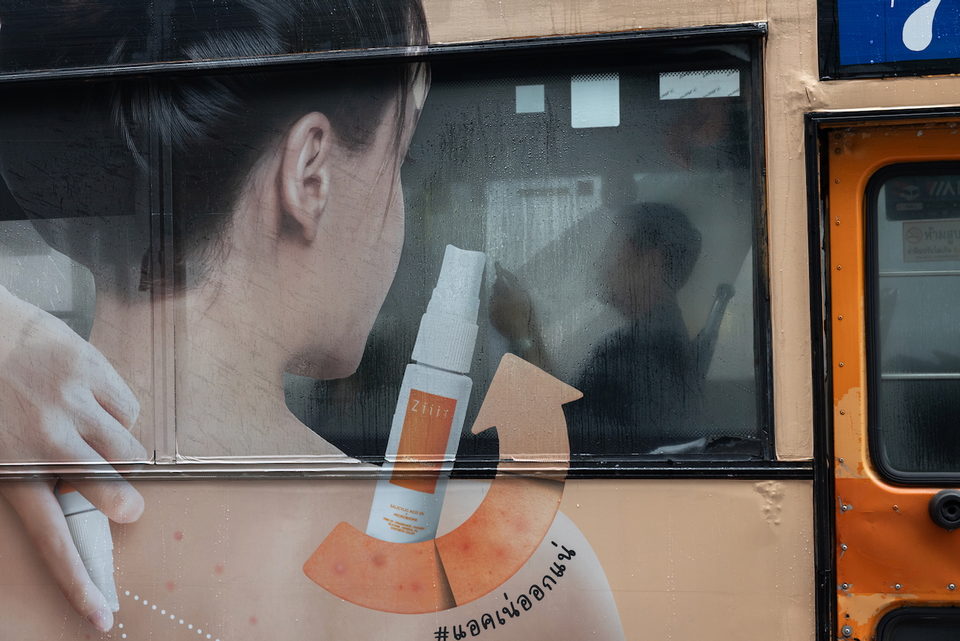 A billboard showing a woman's neck and a cosmetic bottle.