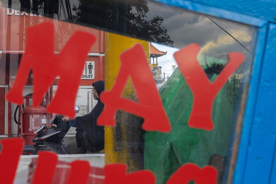 Large red letters over a green awning and a parked motorbike.