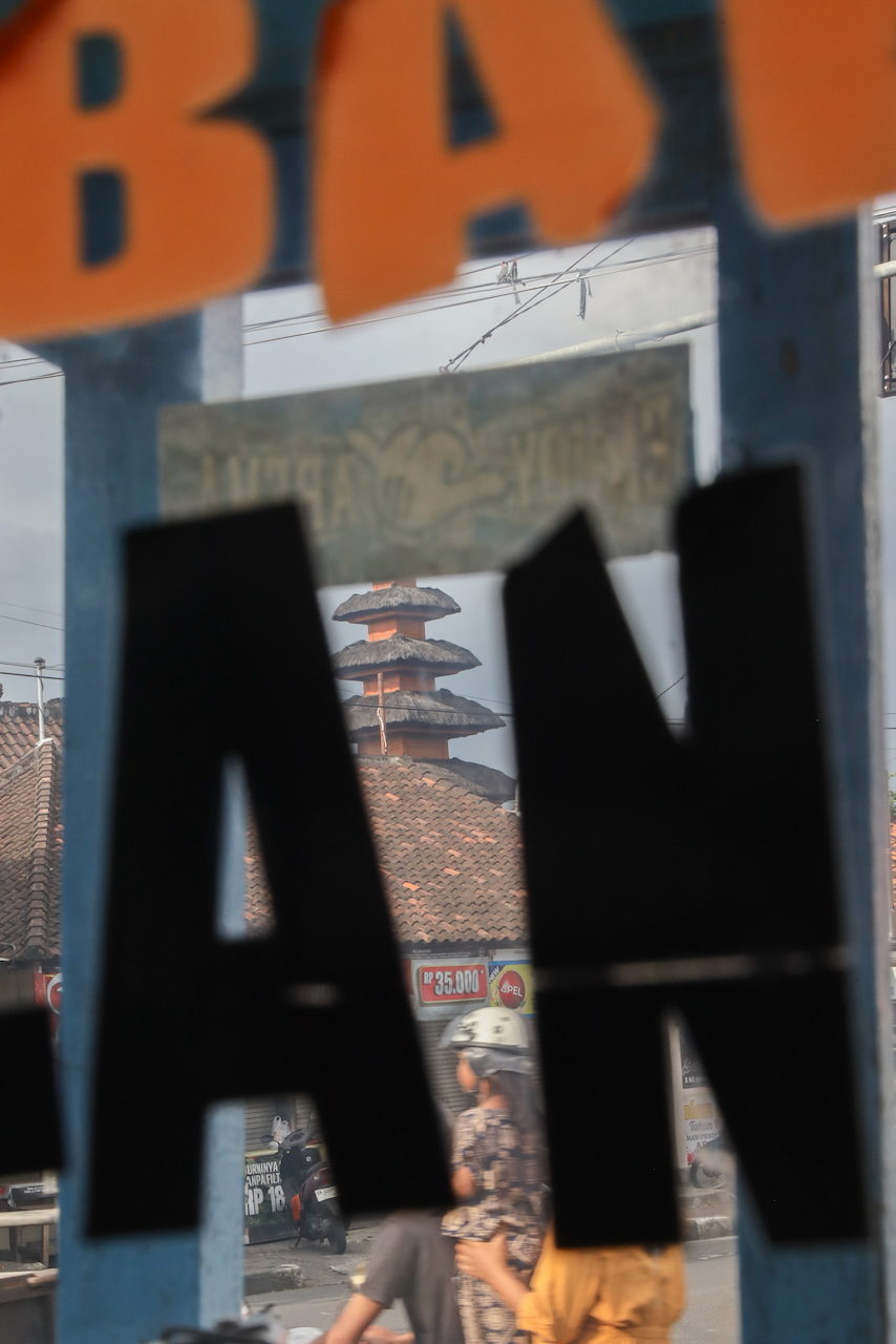 Black letters A and N across a village rooftop and temple shrine.