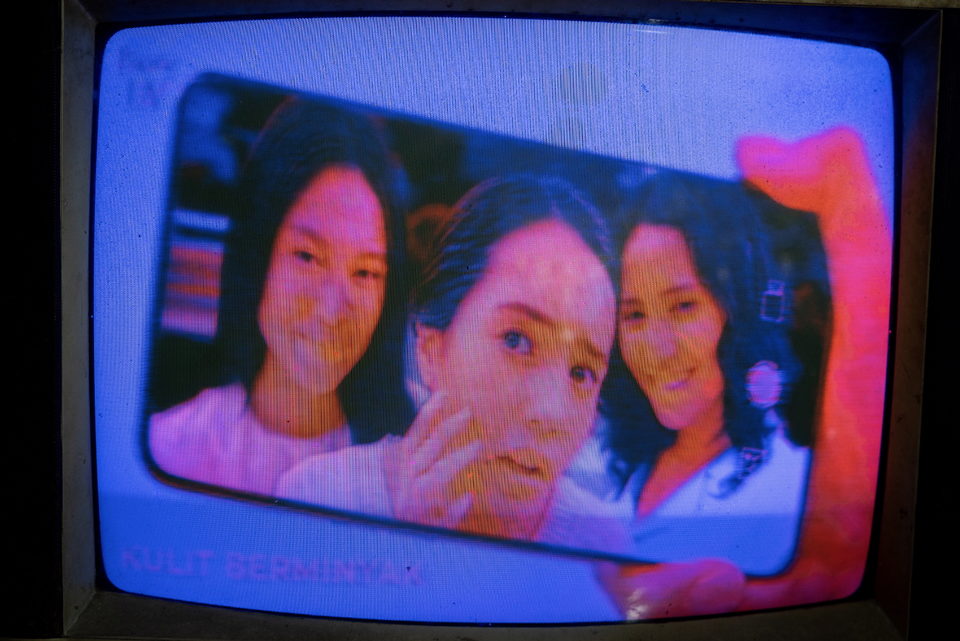 A television close-up of three young women's faces.