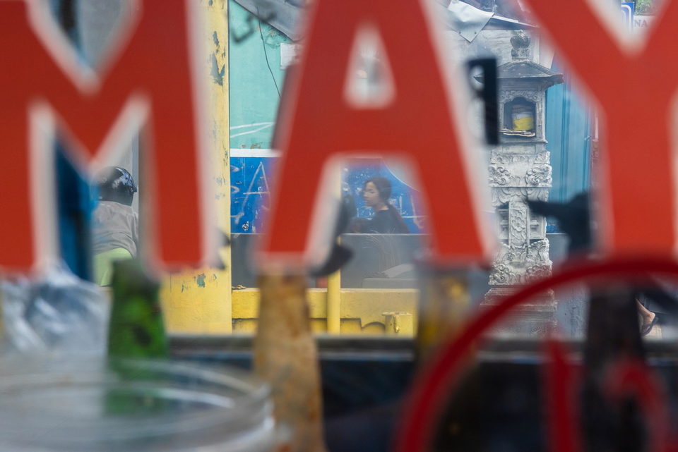 Red letters A and M across a yellow bench and a seated figure.