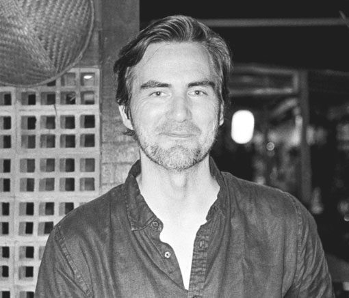 Michael Dean Morgan, photographed in black and white against a latticed wall.