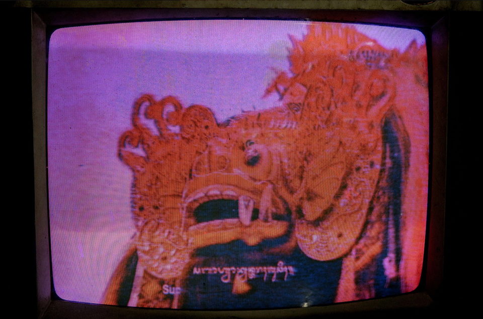 A television showing an ornate shadow-puppet figure in orange.