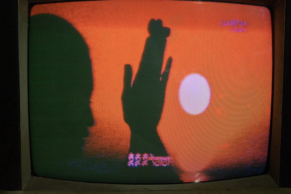 A shadow puppet cast against an orange screen.