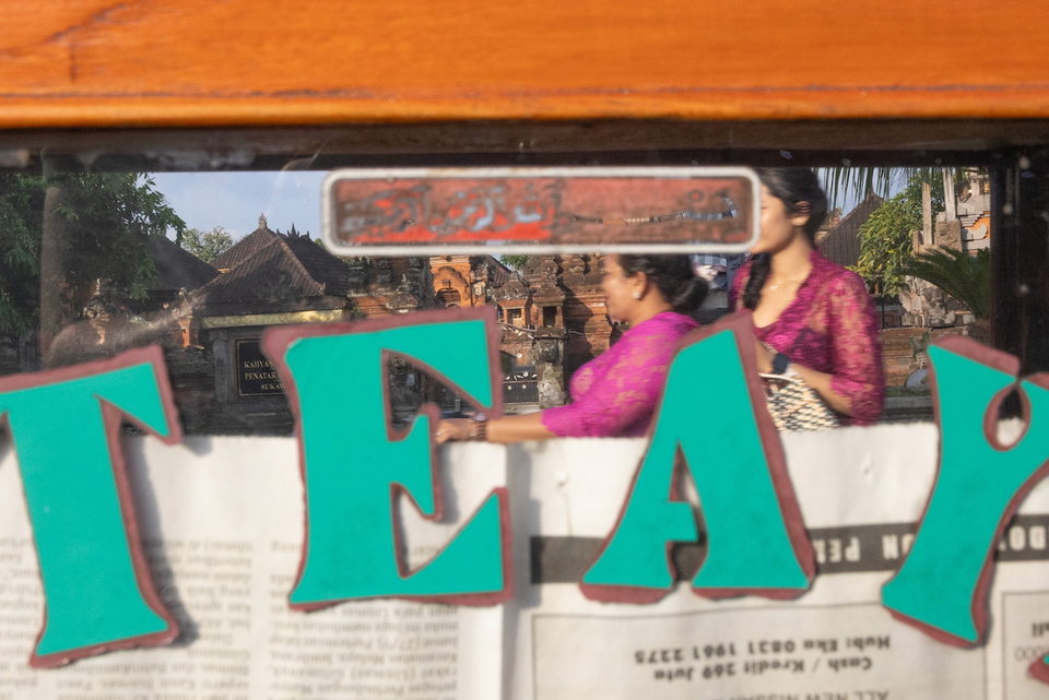 Green letters E and A on the glass, two women in pink beyond.