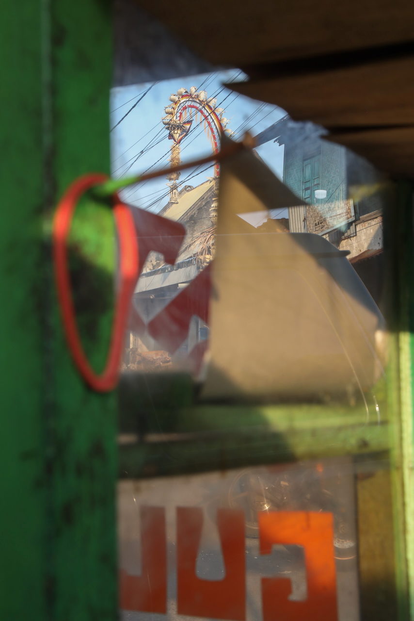 A red ring and pale panel against green, seen through the cart window.