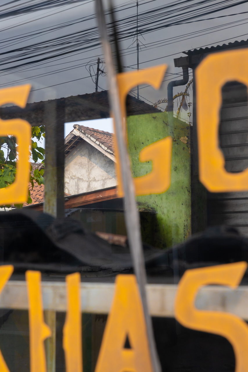 Yellow letters over a rooftop and a dark curved form on the counter.