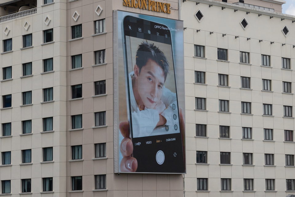A giant phone advertisement on the side of an apartment block.