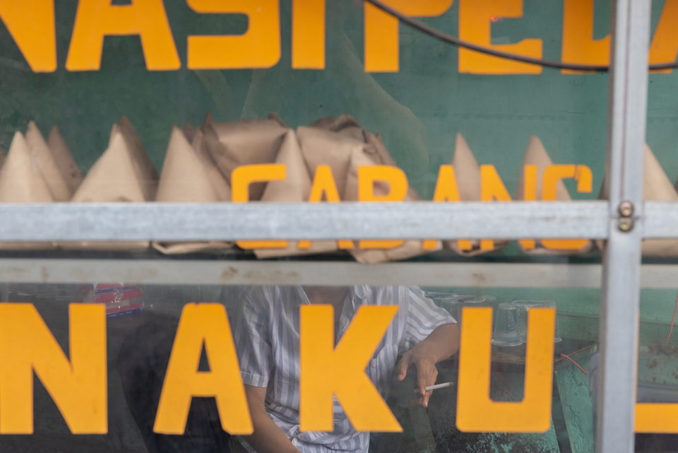 Orange lettering across the cart window, a man leaning on a rail beyond.