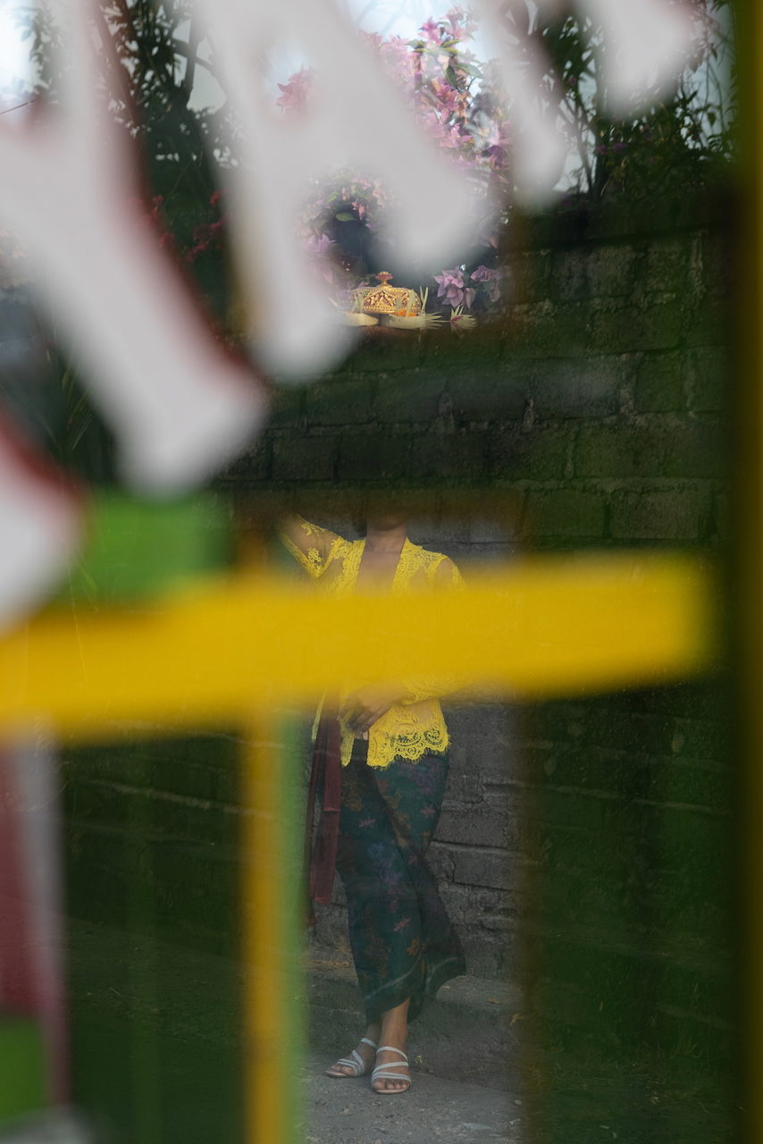 A yellow bar across the glass, a figure in yellow beyond a green wall.