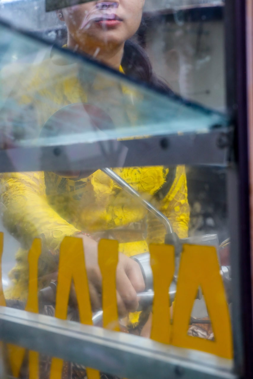 Blue and yellow glass panels over gold lettering and a hand beyond.