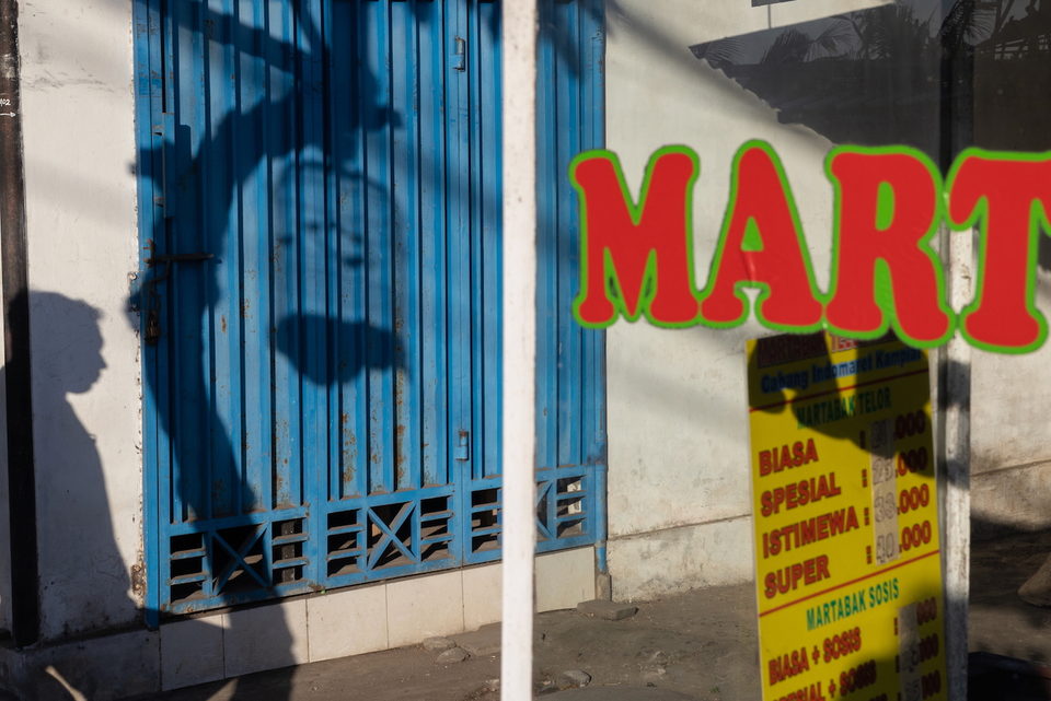 Red and green lettering against a blue shuttered shopfront.